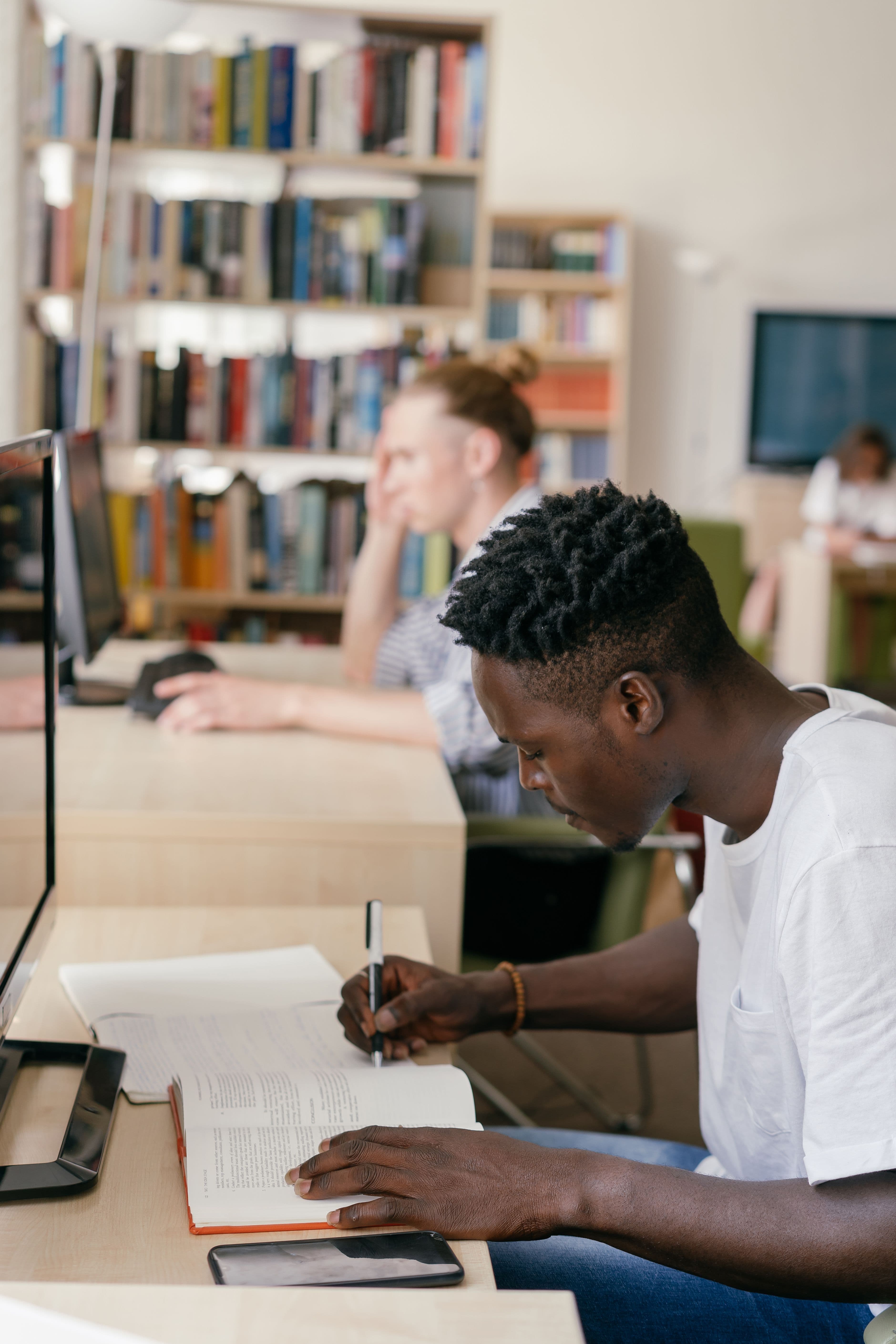 A focused student studying in a bright modern library